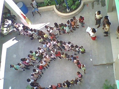 Children Form an X and an O Dancing in the Schoolyard.