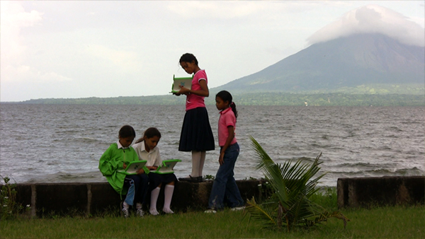 Kids with XOs on Lake Nicaragua shore with volcano in background
